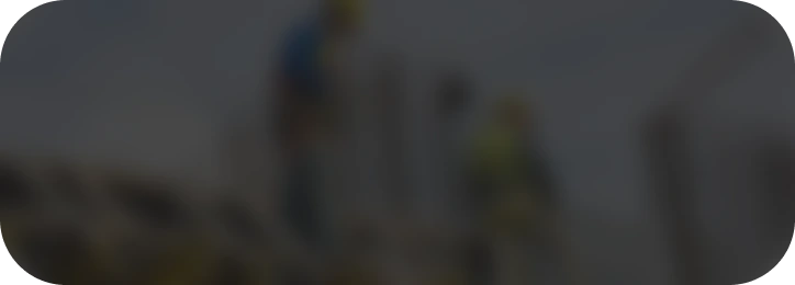 Dos trabajadores de la construcción con cascos y arneses de seguridad, operando en una estructura de acero y encofrado en una obra.